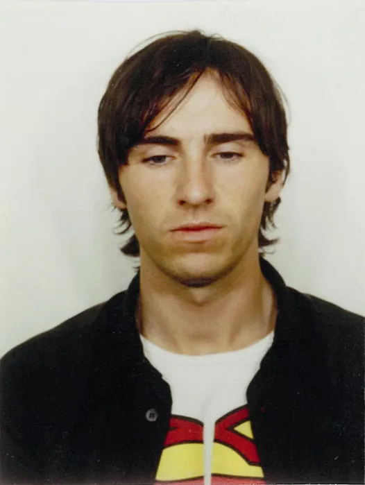 Raf Simons in the 1990s, Superman T-shirt under a dark jacket, colour portrait