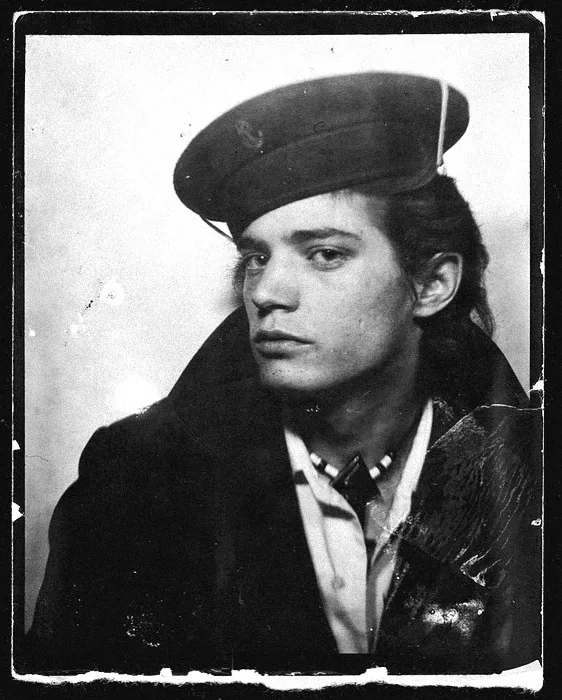 Robert Mapplethorpe in a sailor cap and dark coat, photo-booth portrait