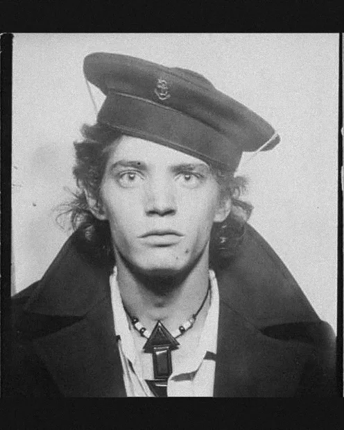 Robert Mapplethorpe in a sailor cap and pendant necklace, photo-booth portrait
